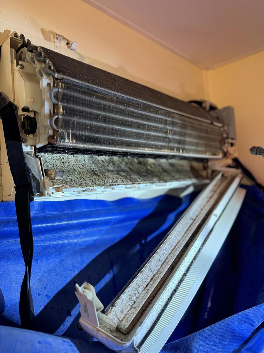 A Dirty Air Conditioner Is Sitting On Top Of A Blue Tarp In A Room — COOLIT NT In Darwin, NT