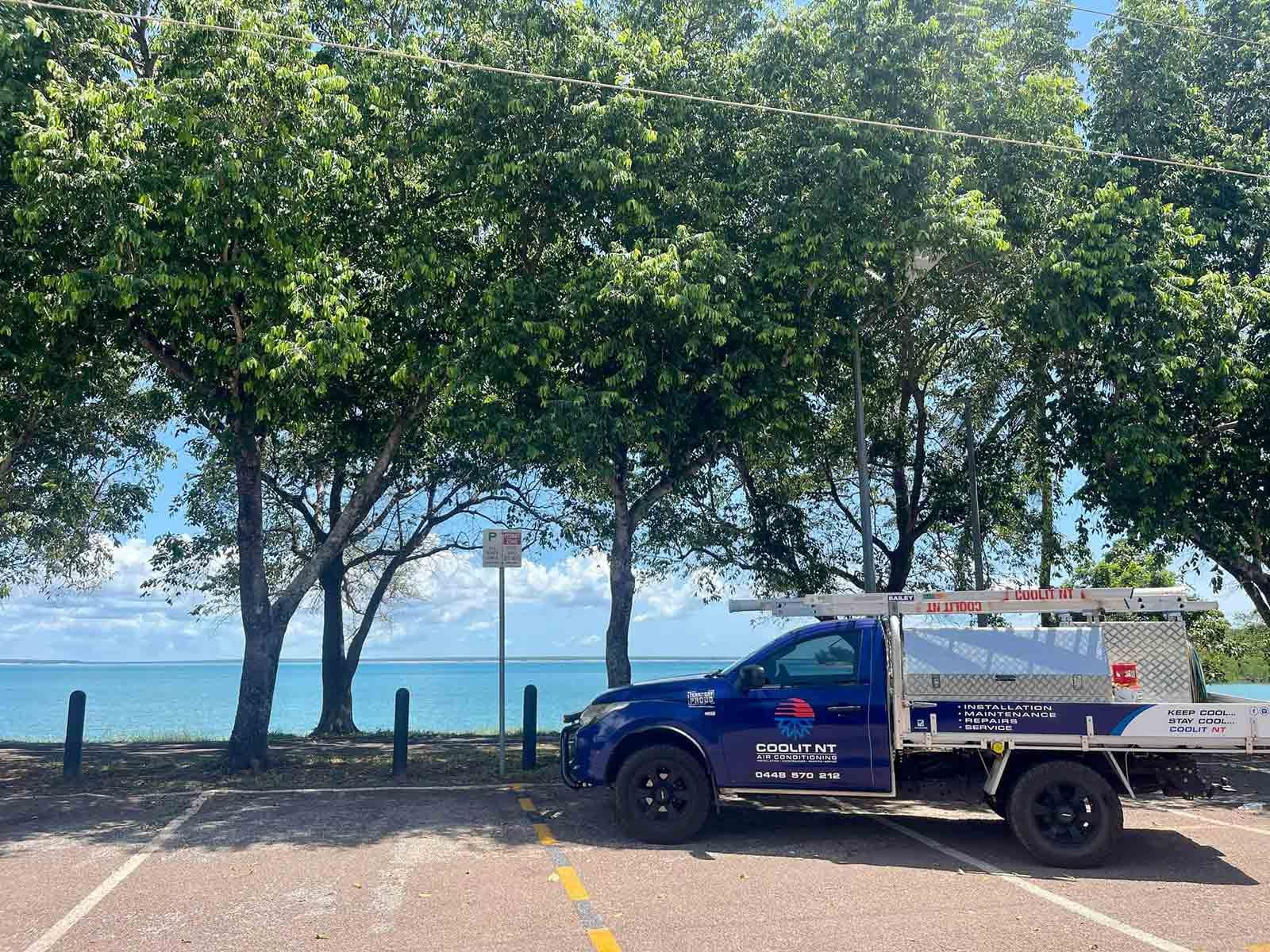 A Blue Truck Is Parked In A Parking Lot Next To A Body Of Water — COOLIT NT In Berrimah, NT