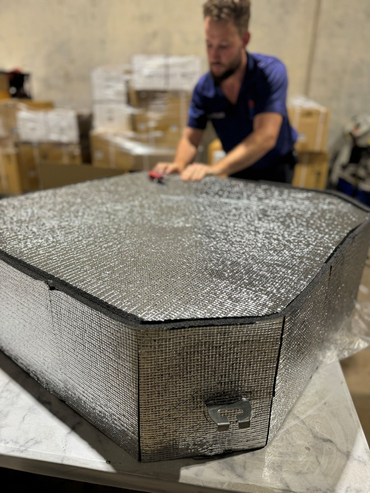A Man Is Working On A Piece Of Metal On A Table — COOLIT NT In Berrimah, NT