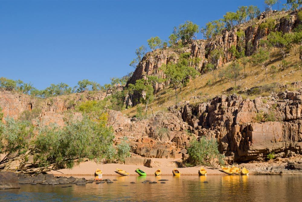 A Group Of Kayaks Are Sitting On The Shore Of A River — COOLIT NT In Katherine, NT