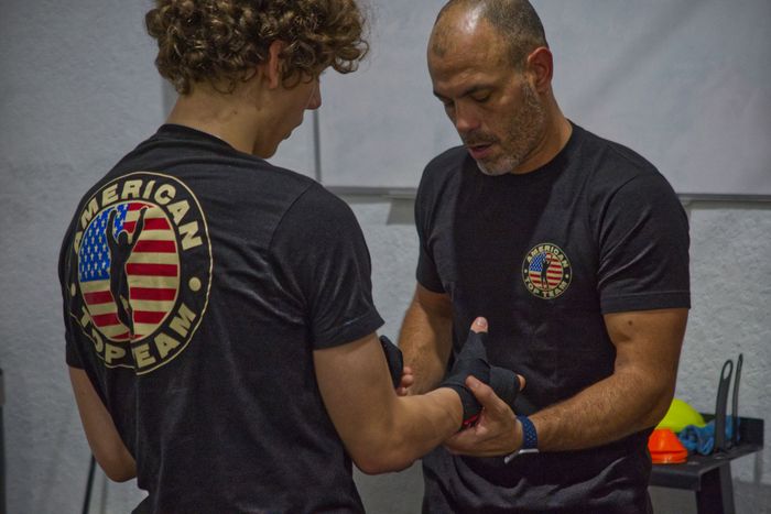 Coach at American Top Team Aventura/NMB helping a student wrap their hands for class