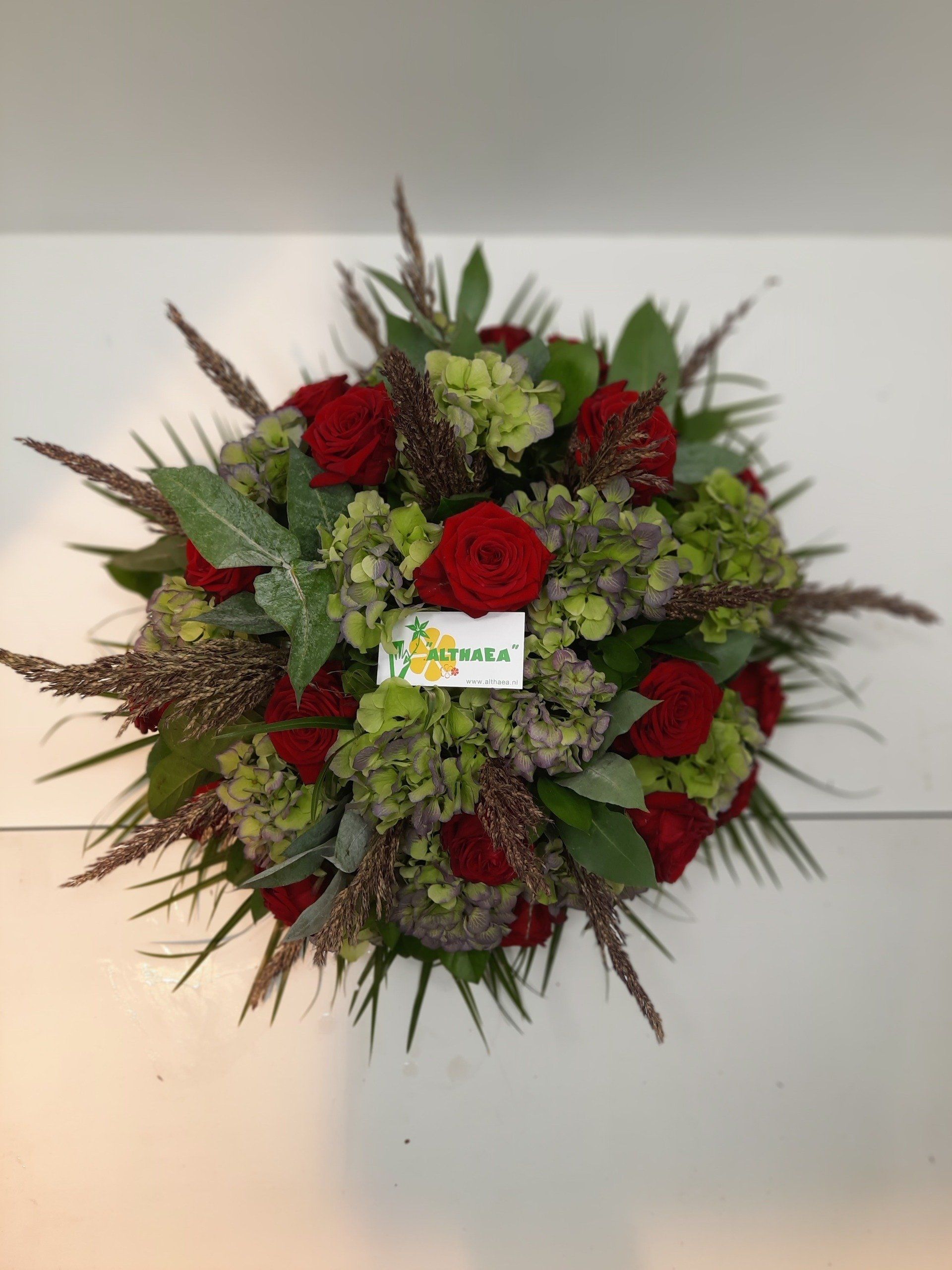 rood rouwstuk in de vorm van een biedermeijer bij Althaea Bloemsierkunst