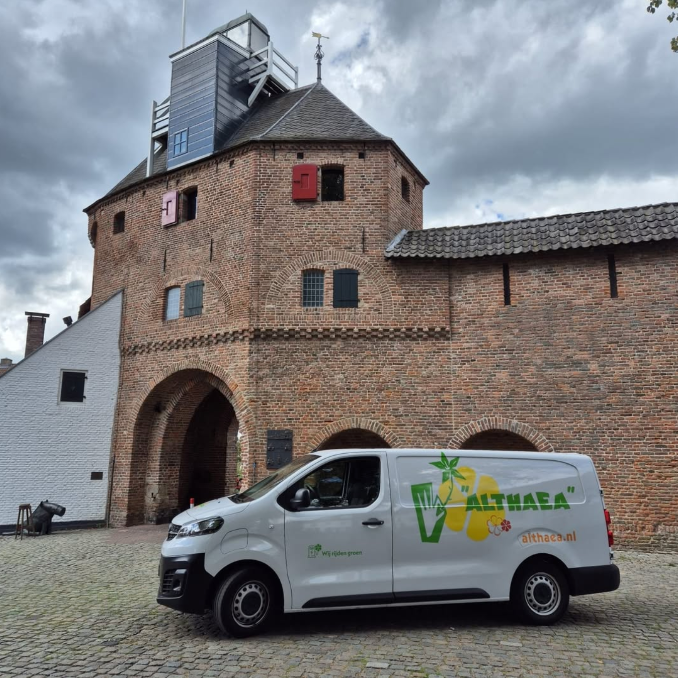 De witte Althaea bestelwagen geparkeerd voor de Vischpoort in Harderwijk
