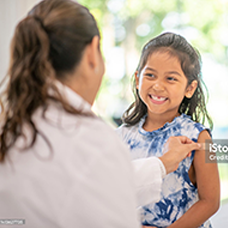 Doctor smiling with a young patient in a bright clinic setting