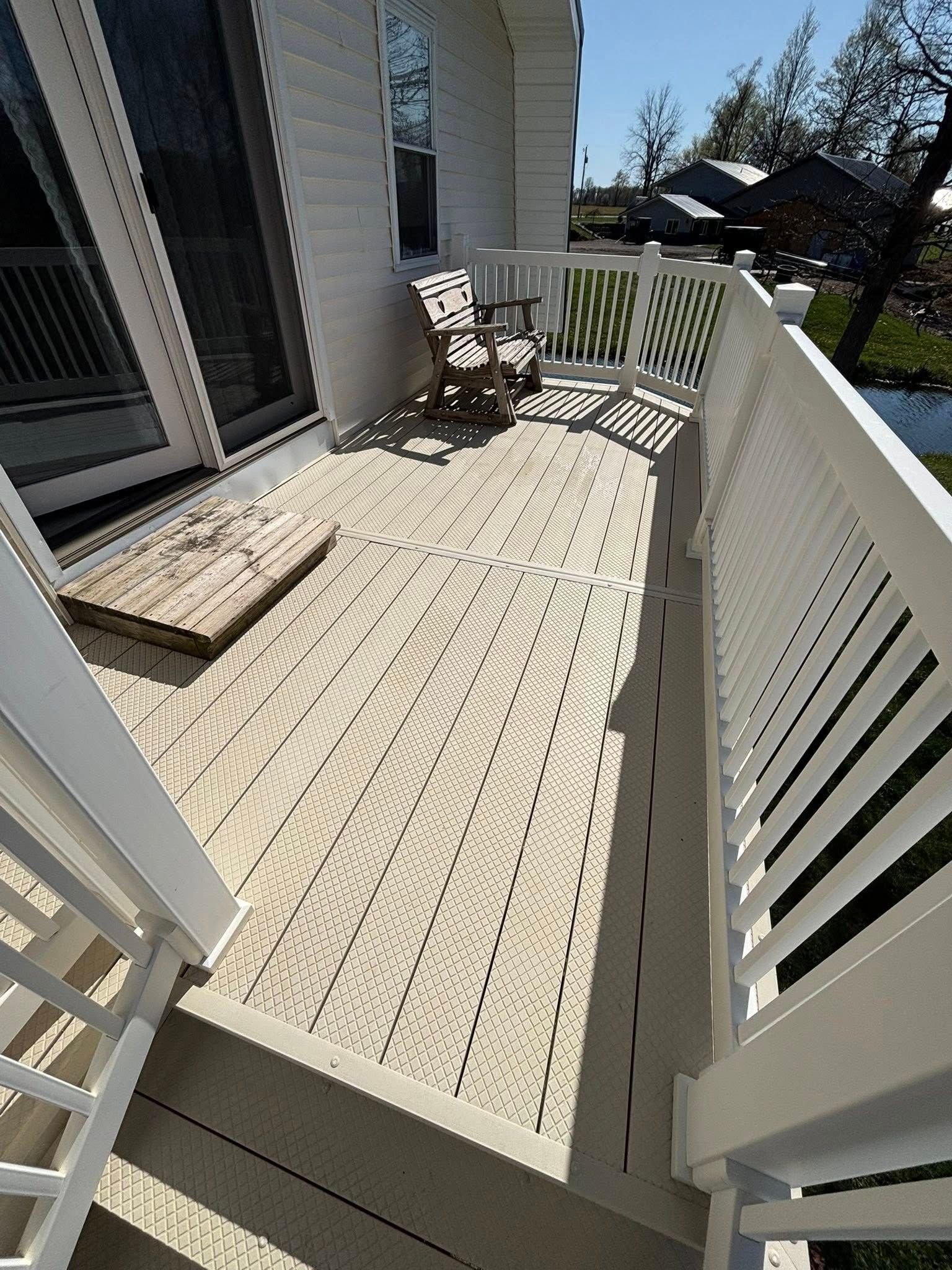 A deck with a rocking chair and a rug on it