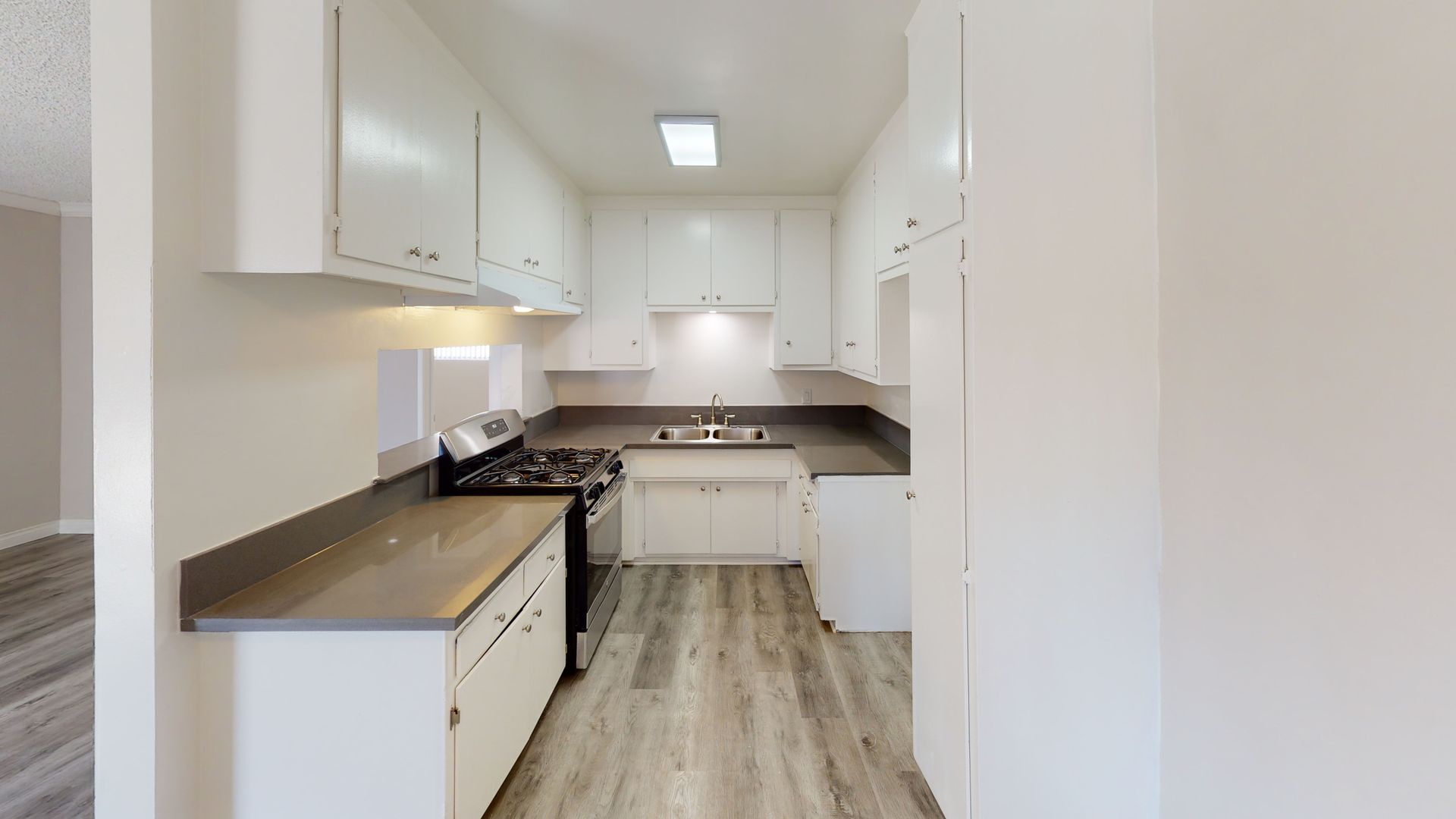 Kitchen with white cabinets, gray countertops, and stainless steel appliances.