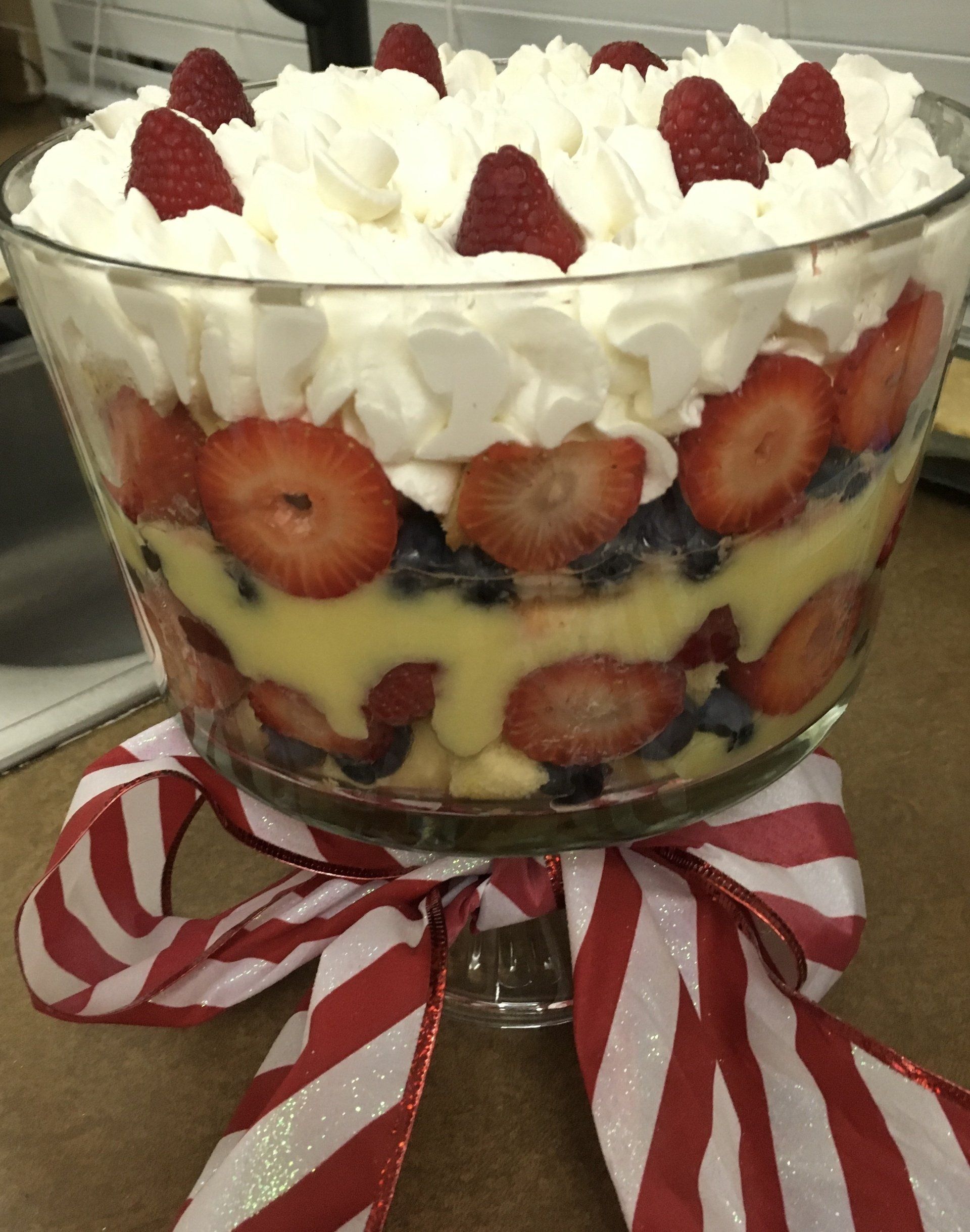 A trifle with whipped cream strawberries and blueberries