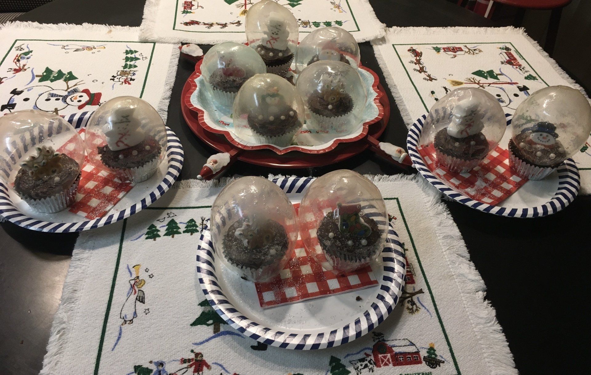 Four plates with cupcakes on them on a table