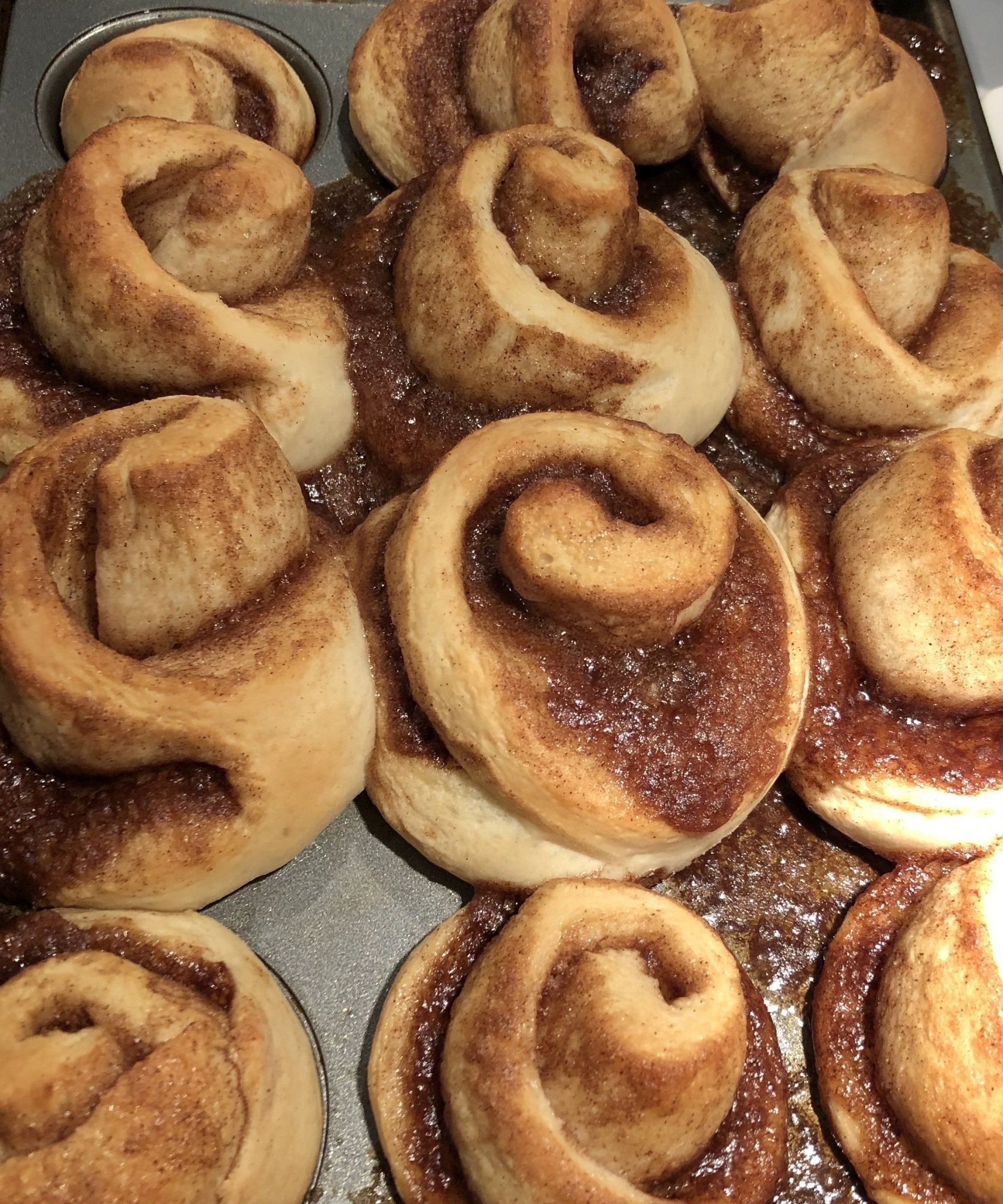 A bunch of cinnamon rolls in a muffin pan