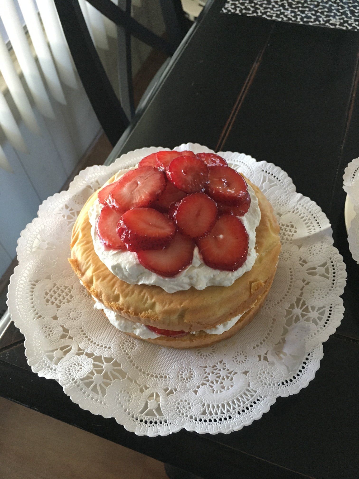 A cake with strawberries and whipped cream on top