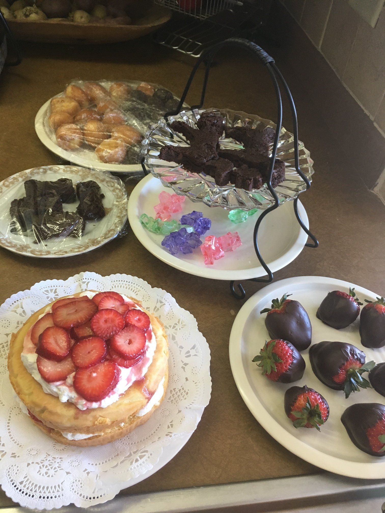 A table topped with plates of desserts including strawberries and chocolate covered strawberries