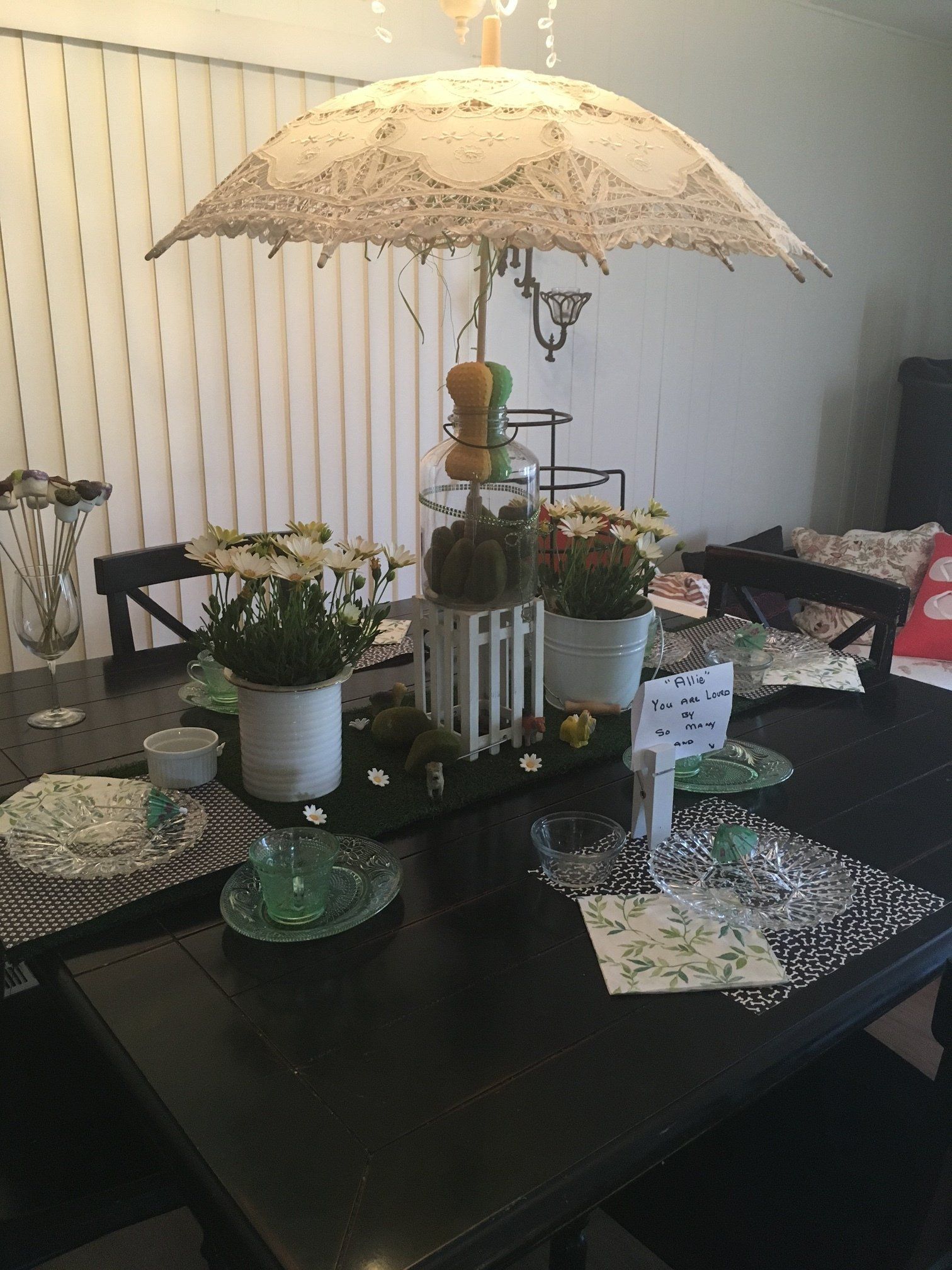 A table with a white umbrella and flowers on it