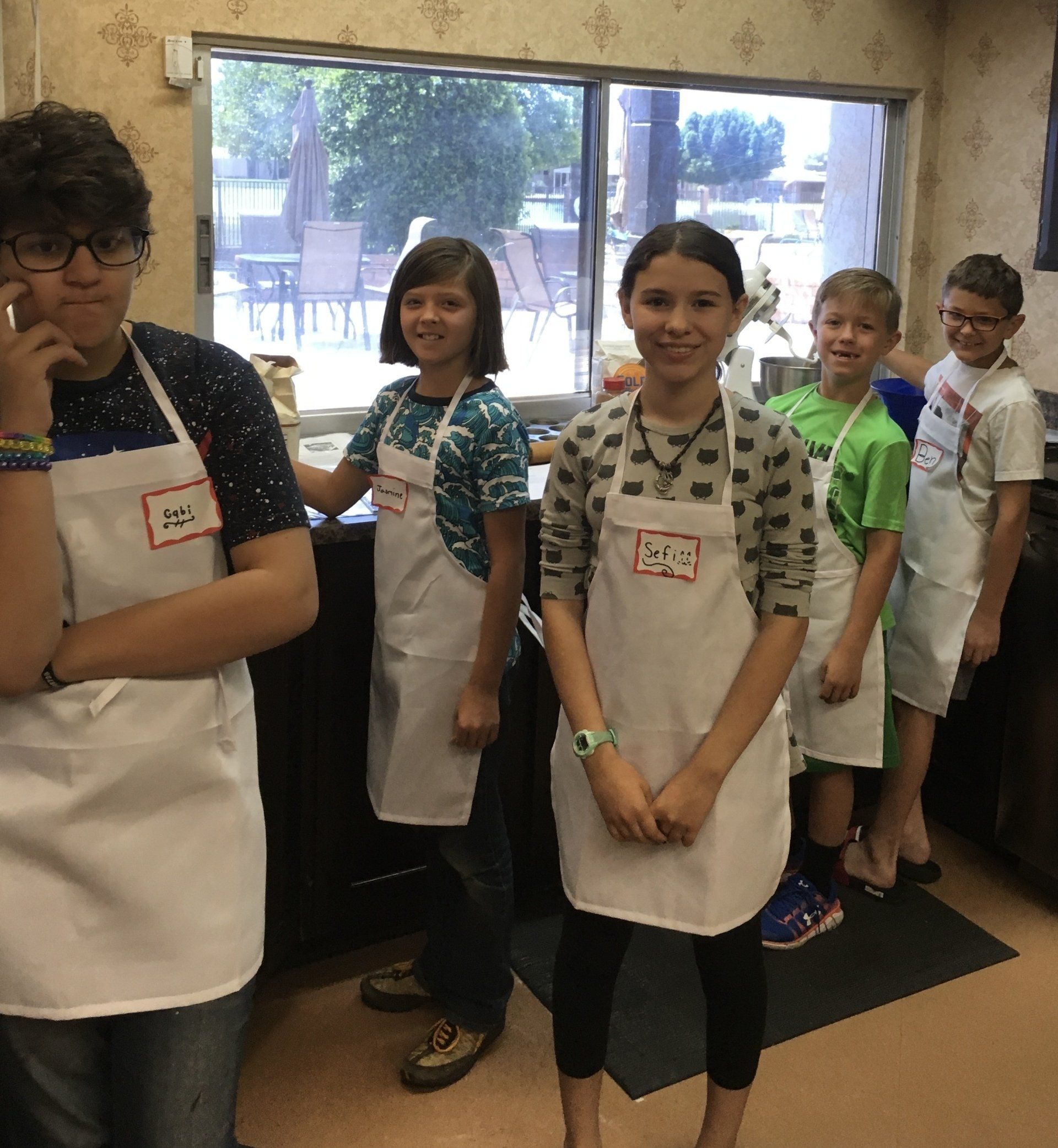A group of children wearing aprons with the letters pa on them