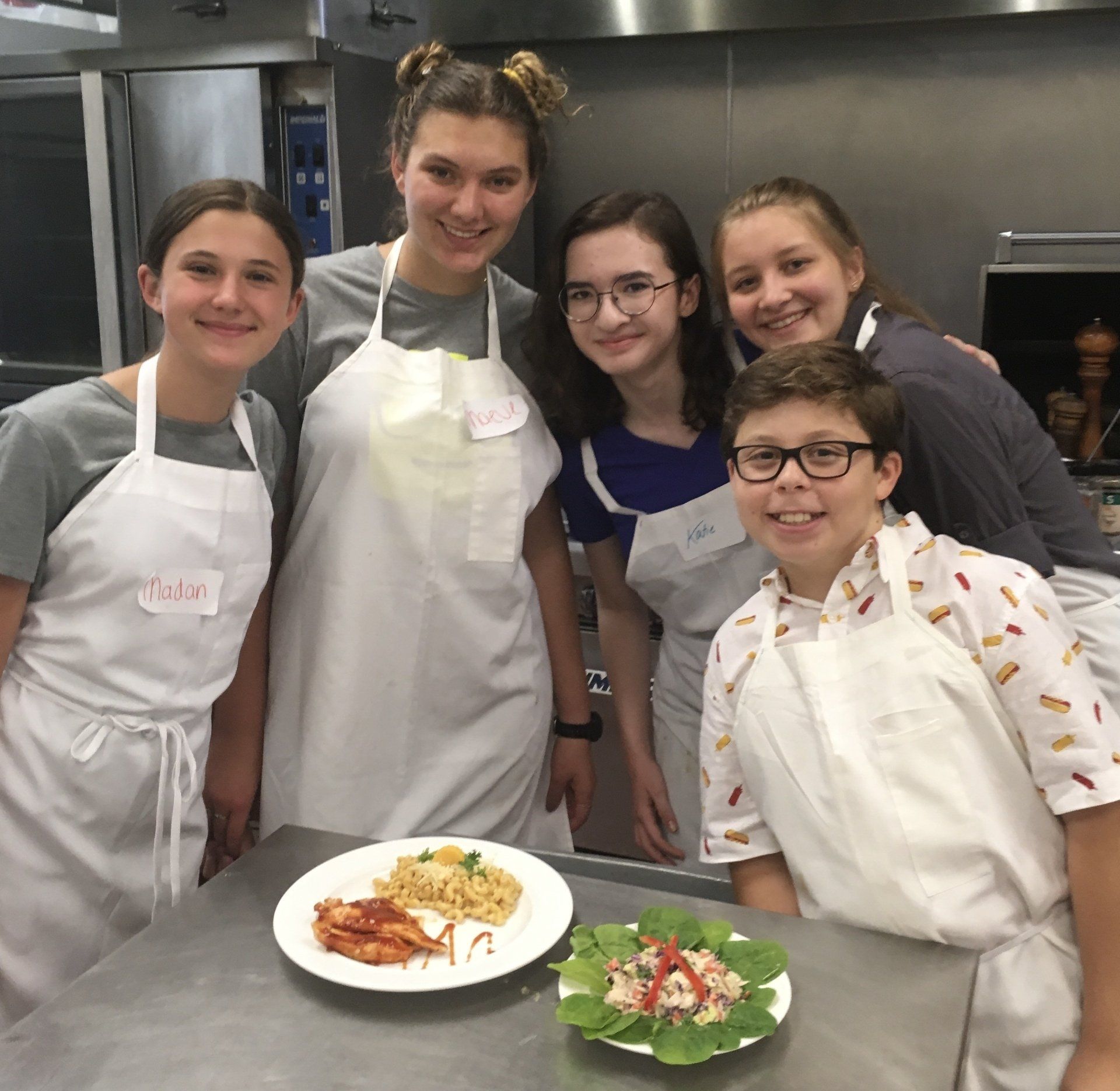A group of people posing for a picture in front of a plate of food
