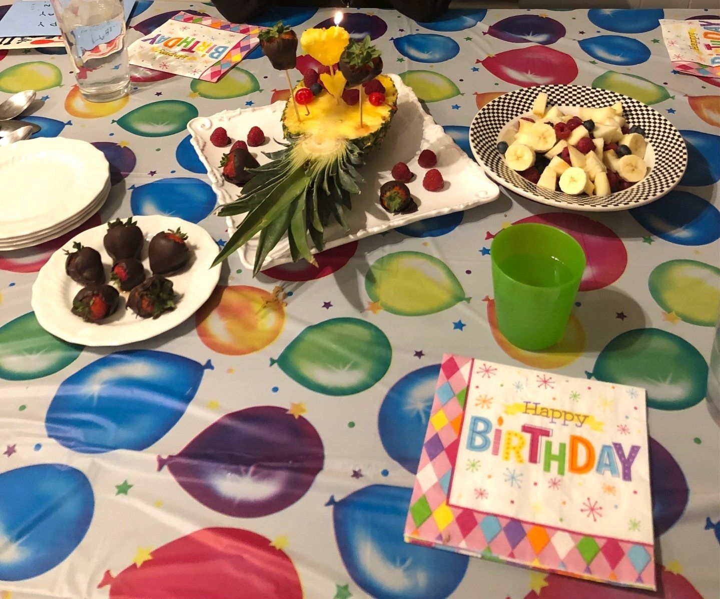 A table with plates of fruit and a napkin that says happy birthday