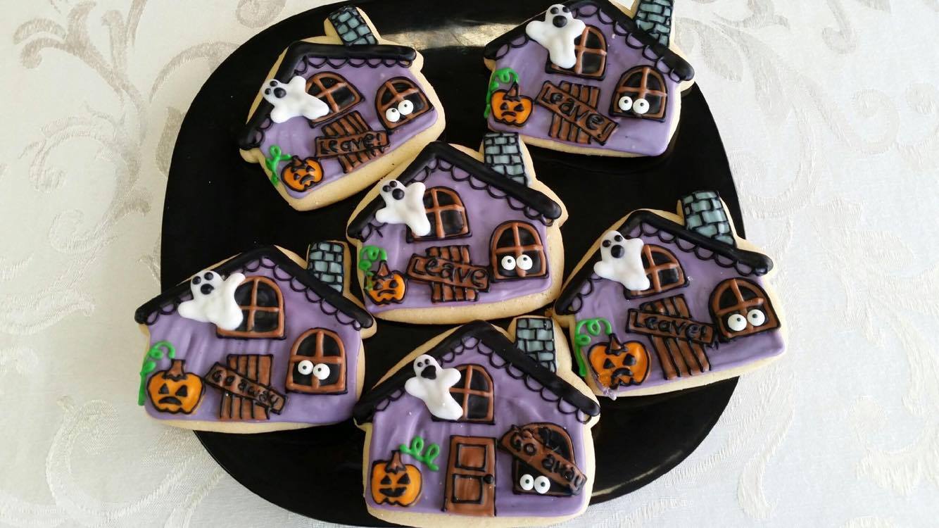 A plate of halloween cookies in the shape of haunted houses