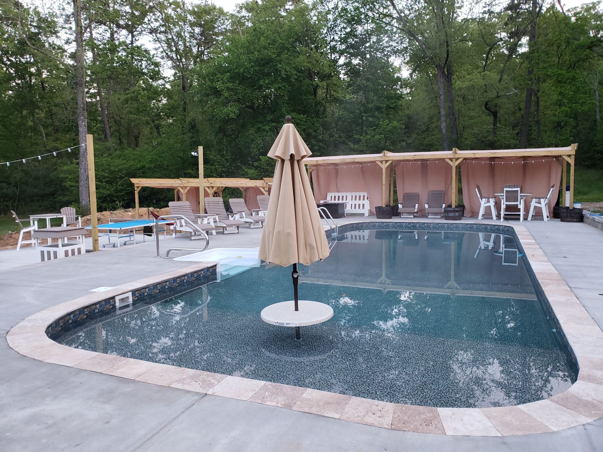 A large swimming pool with umbrellas and chairs around it