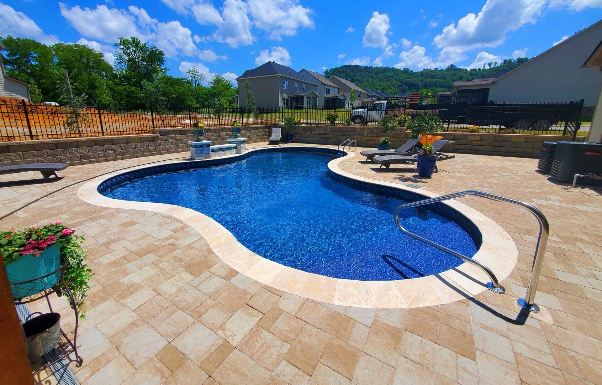 There is a large swimming pool in the backyard of a house.