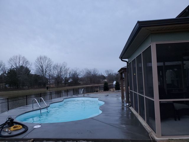 A screened in porch next to a swimming pool