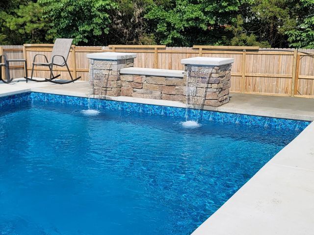 There is a waterfall in the middle of the pool.