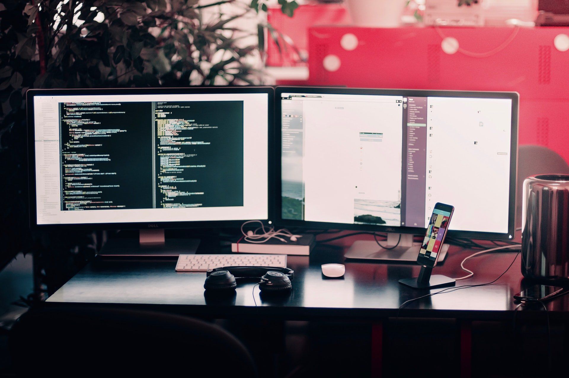 Two computer monitors are sitting on a desk next to each other.