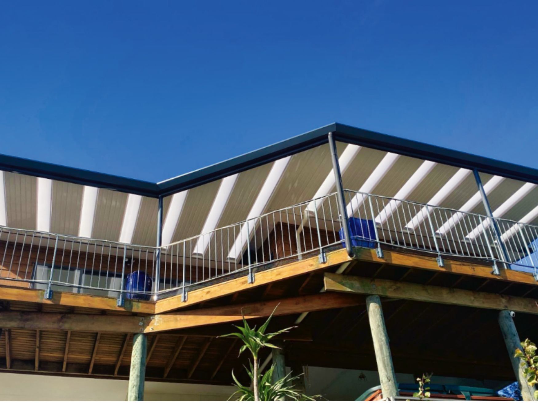 A house with a balcony with striped awnings on it