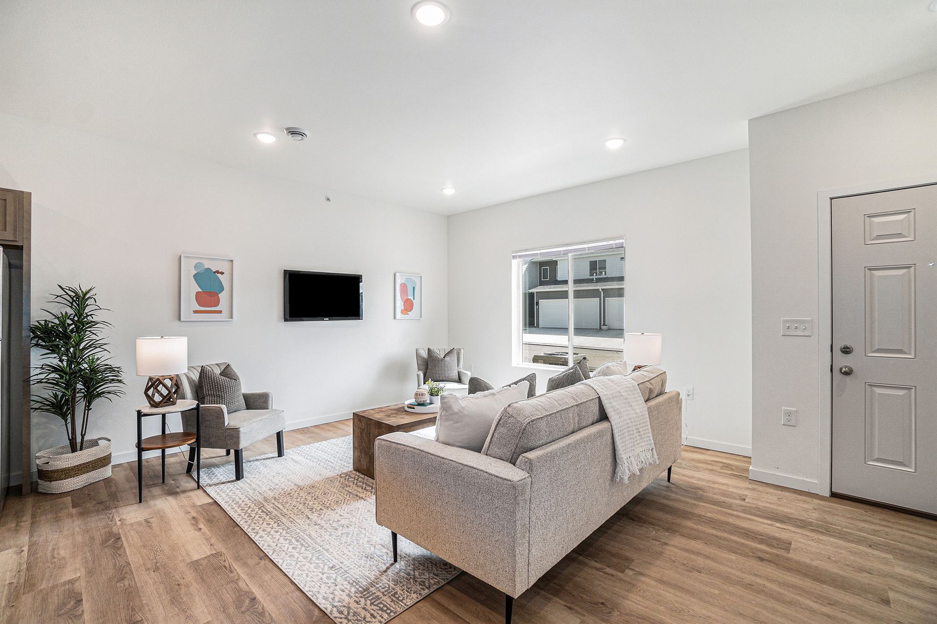 A living room with a couch , chairs , table and television.