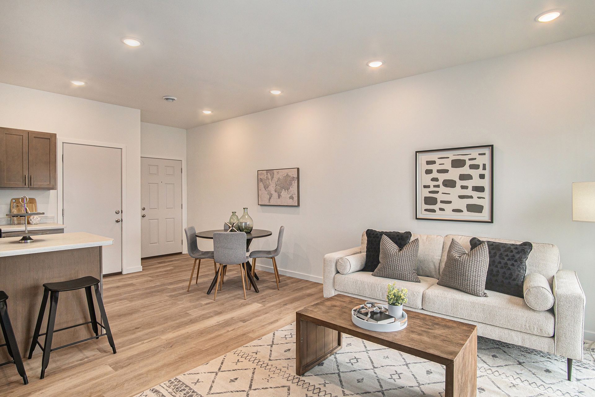 A living room with a couch , coffee table , dining table and chairs.