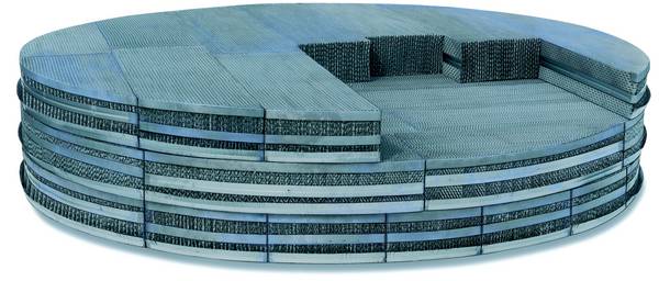 A round couch with pillows on it is sitting on a white surface.