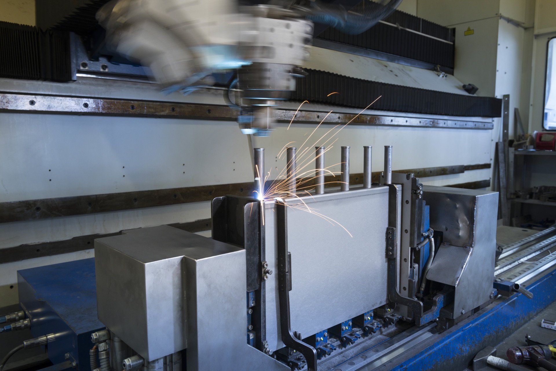 In einer Fabrik schneidet eine Maschine ein Stück Metall.