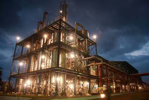 A large industrial plant is lit up at night.