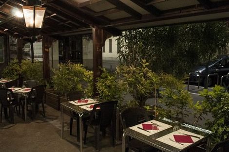 Un ristorante con tavoli e sedie sotto una tettoia
