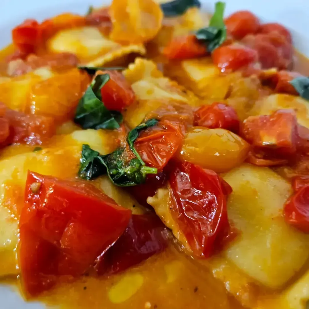Ravioli con pomodorini e basilico in salsa.