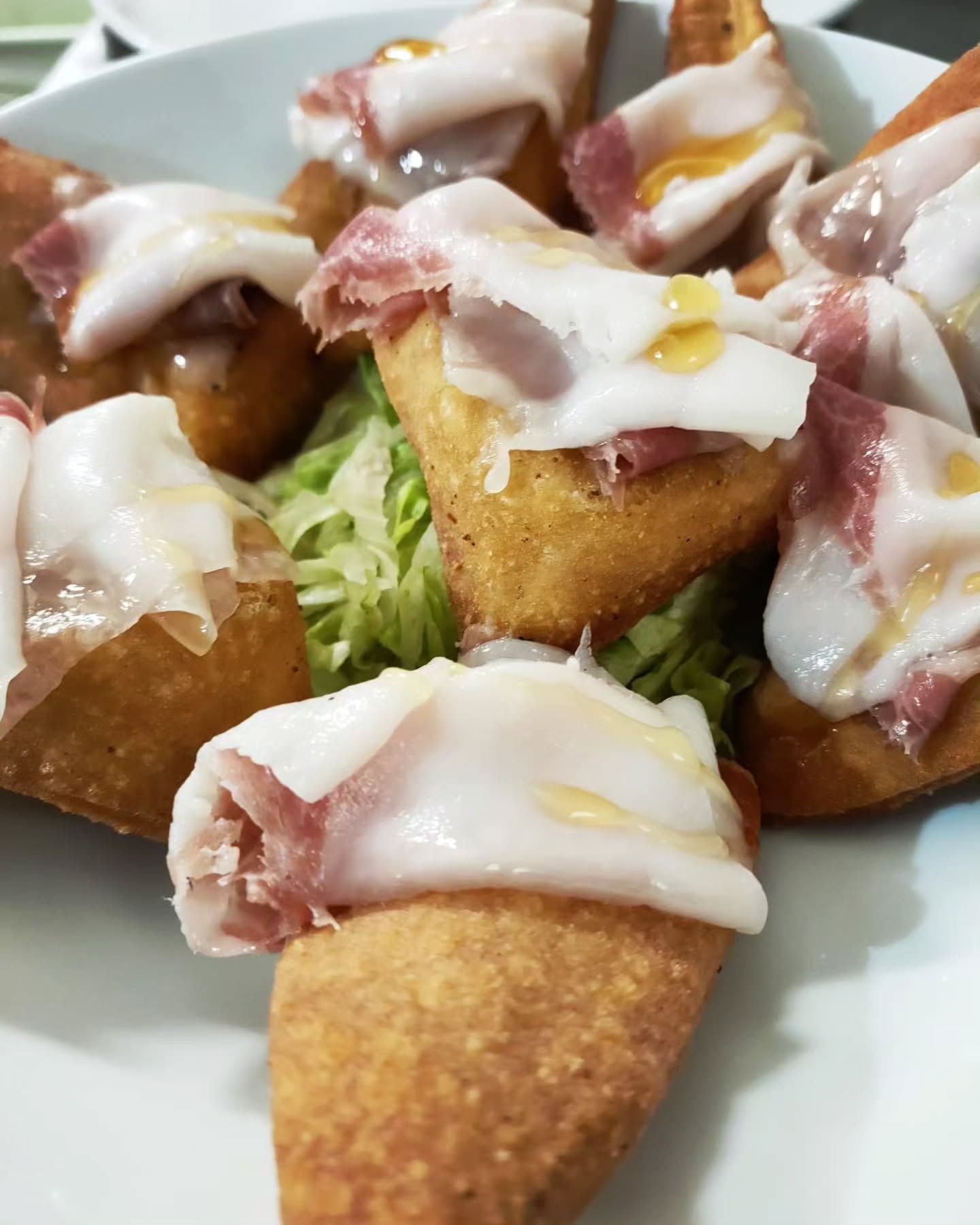 Pane fritto condito con carne stagionata, un filo d'olio e lattuga.