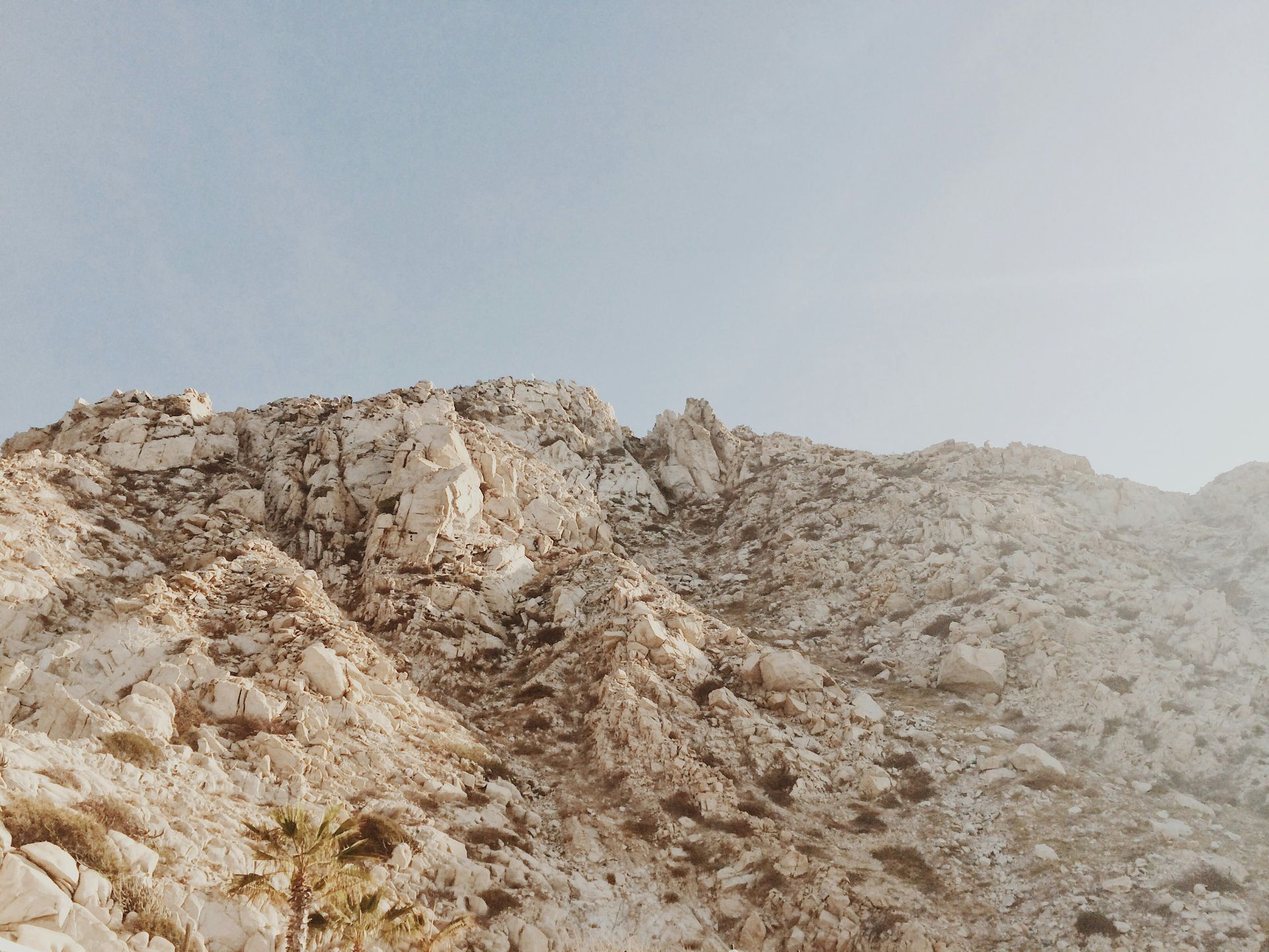 A mountain covered in rocks with a blue sky in the background.