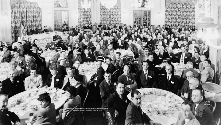 A large group of people are sitting at tables in a room.