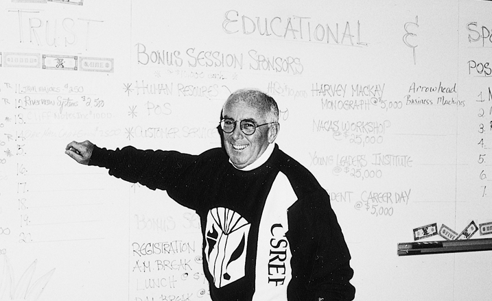 A man standing in front of a white board that says educational