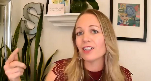 Shasta Nelson standing in front of a shelf with a picture on it.