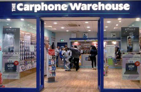 A group of people are standing in front of a store called the carphone warehouse