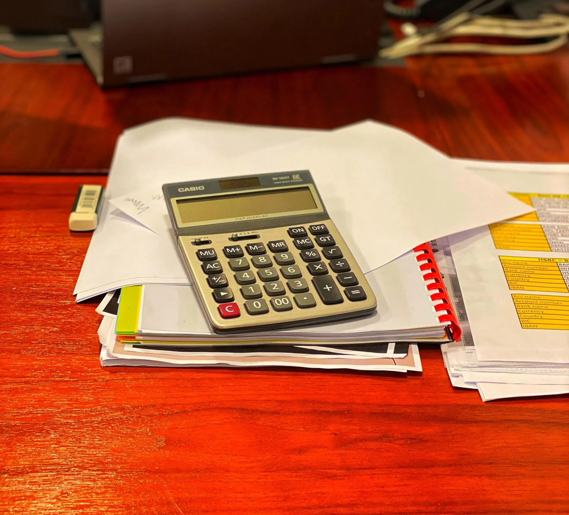 A calculator is sitting on top of a pile of papers