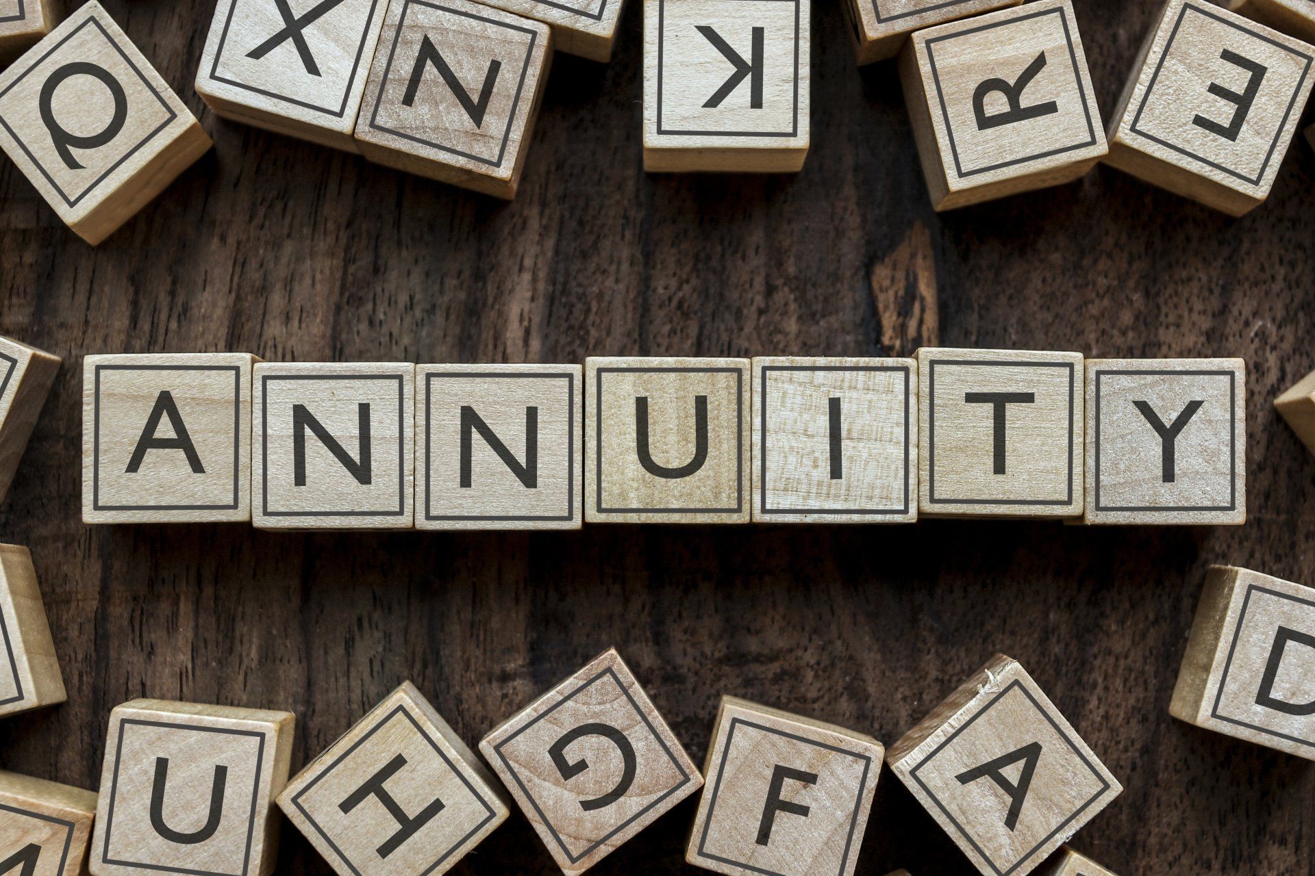The word annuity is written in wooden blocks on a wooden table.