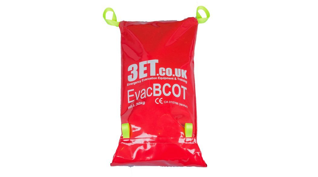 Red EvacBCOT rescue cot in a bag, with yellow handles, against a white background.