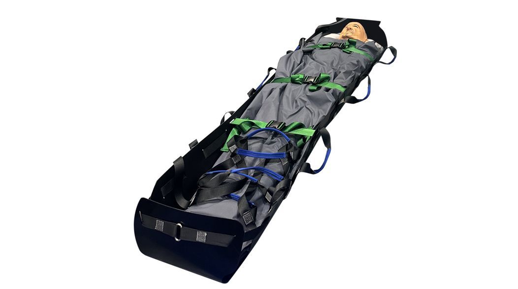 Person secured in a black body bag with green and blue straps, preparing for transport.