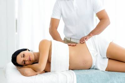 Pregnant woman laying on her side during a massage