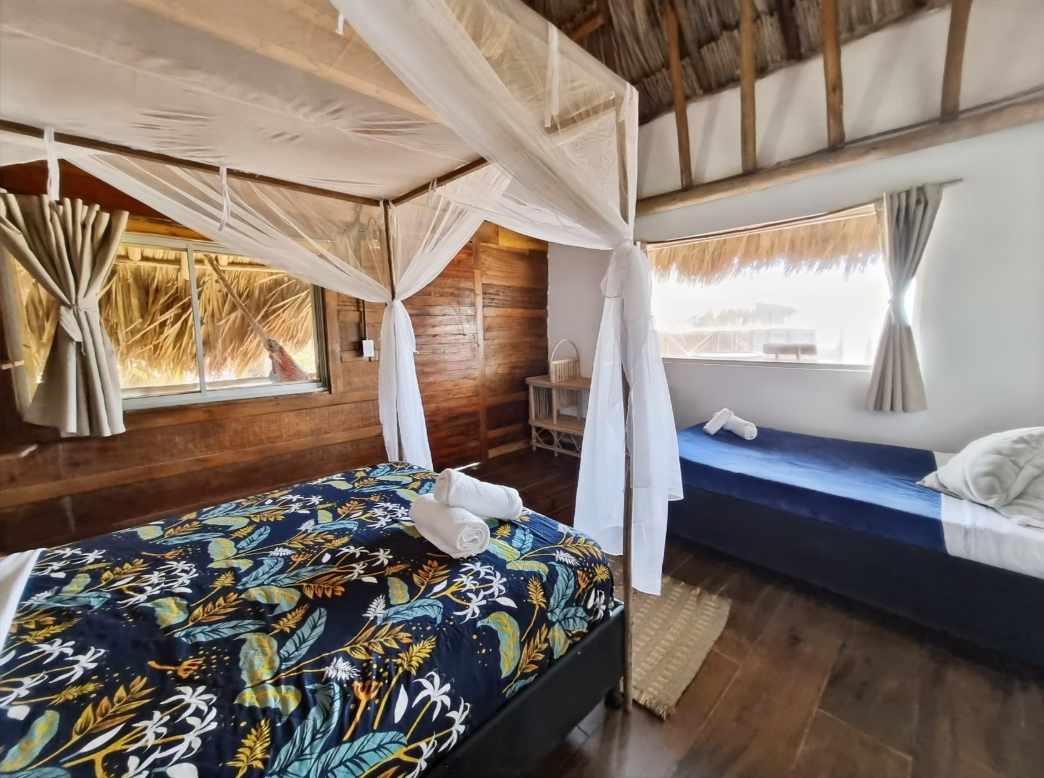 A bedroom with a canopy bed and two beds.