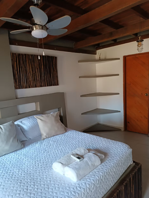 A bedroom with a bed and a ceiling fan