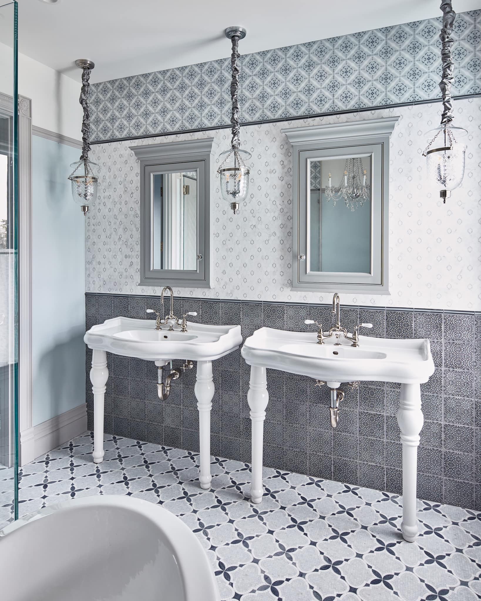 A bathroom with two sinks , two mirrors and a bathtub.