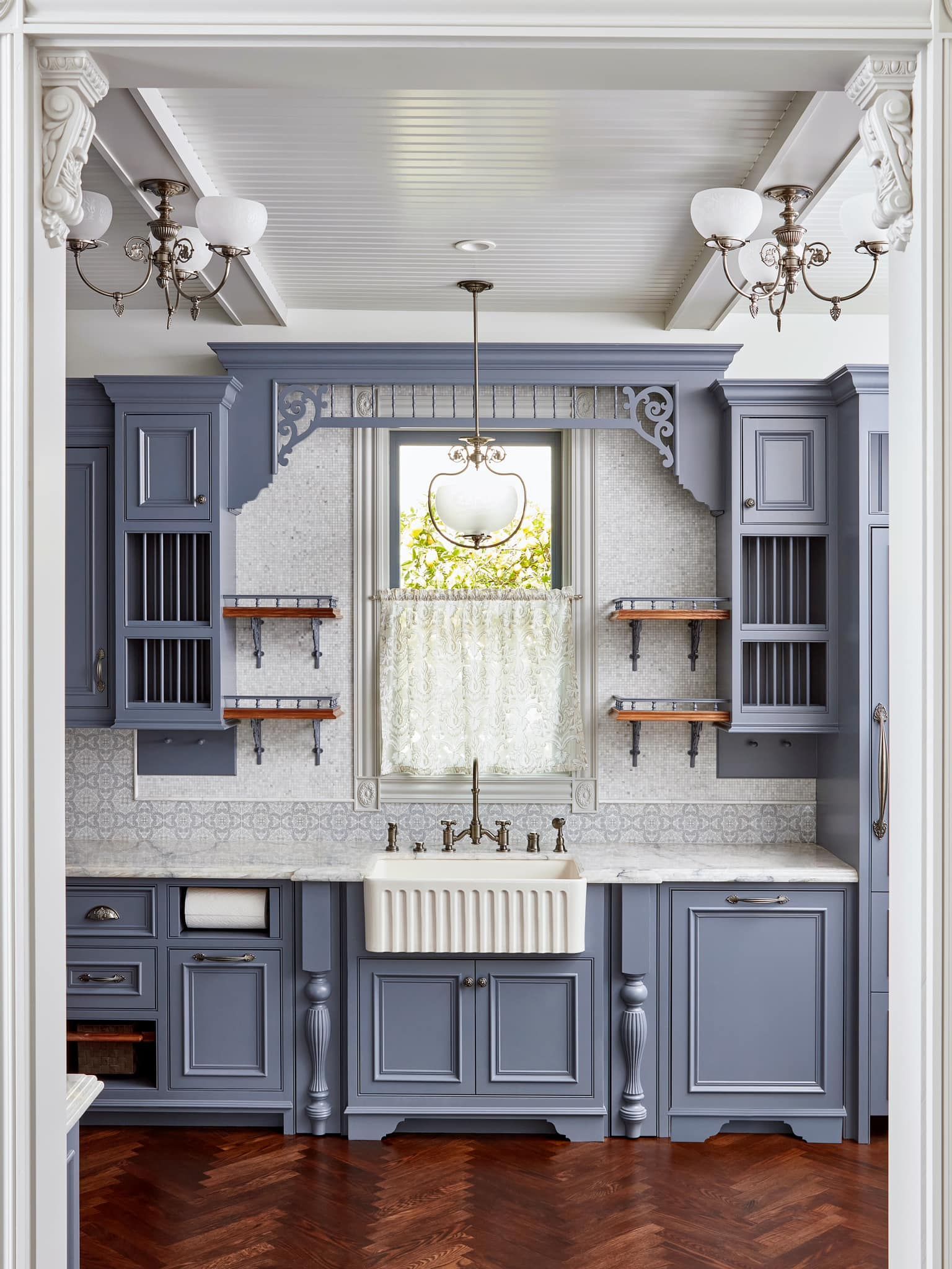 A kitchen with gray cabinets and a white sink