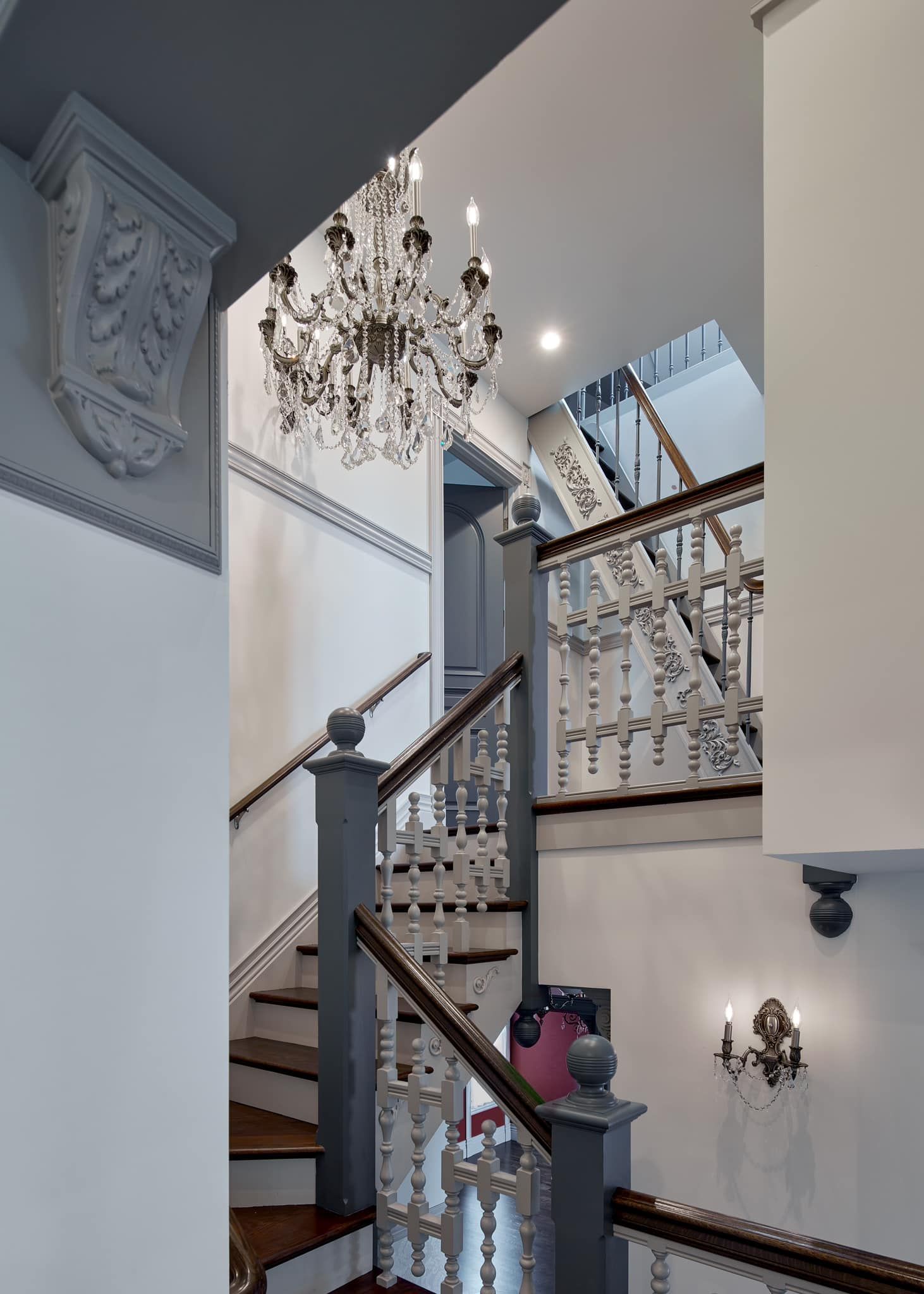 A staircase with a chandelier hanging from the ceiling