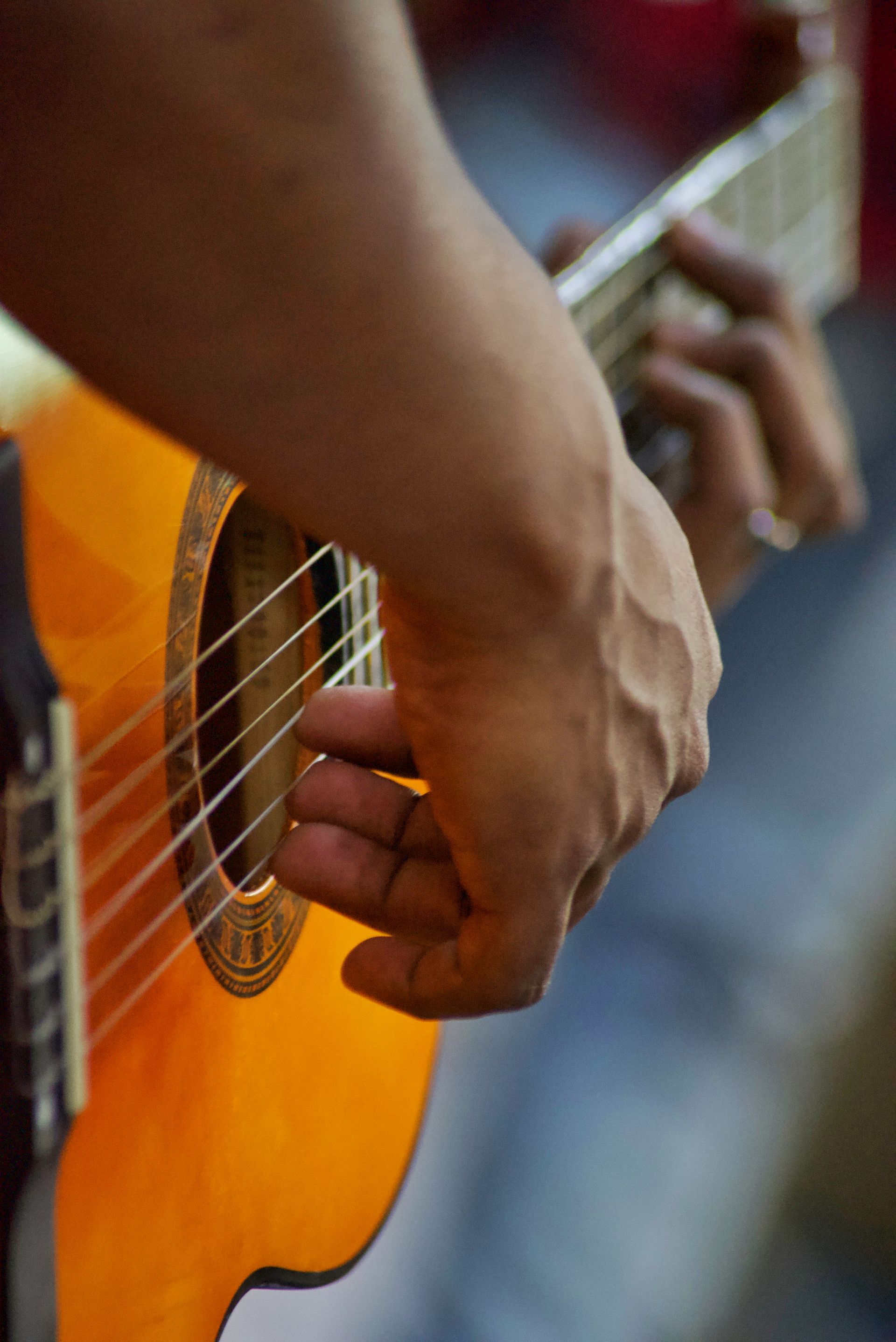 A close up of a person playing an acoustic guitar